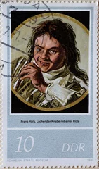 Foto op Canvas GERMANY, DDR - CIRCA 1980 : a postage stamp from Germany, GDR showing a painting “Laughing Boy with a Flute” for Frans Hals' 400th birthday © zabanski