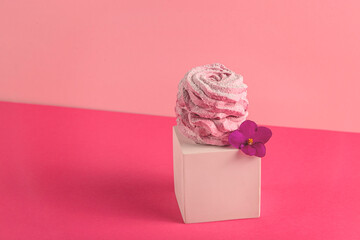 Pink berry marshmallows with spring flowers on white geometric figures on pink background