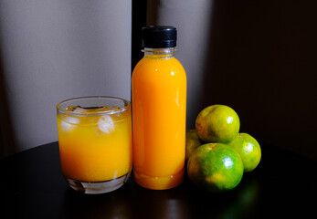 The bottle of orange juices  with fresh oranges