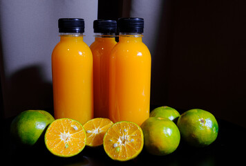 The bottle of orange juices  with fresh oranges