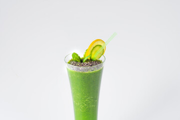 Green smoothie with antioxidant drink prepared with green fruits and vegetables against a white background.