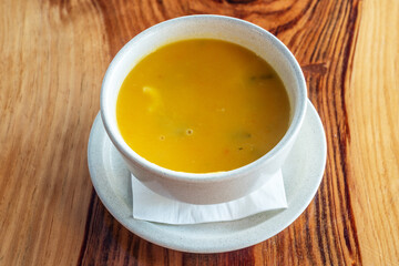 Simple traditional orange colored portuguese soup with vegetables and macaroni.