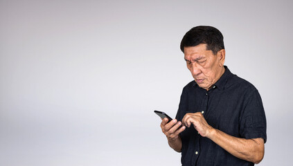 Eye sight problem of asian senior man using mobile phone