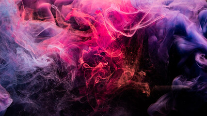 Ink in water. Colorful background. Abstract fume cloud texture. Mystic energy. Glowing bright neon magenta pink purple mist floating on dark.
