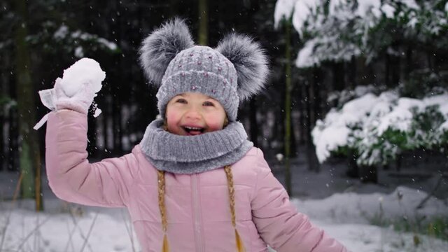Handheld video of little girl throwing a snowball. Shot with RED helium camera in 8K.