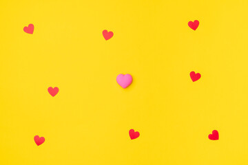 Red and pink hearts isolated on an empty colorful yellow background. Symbol of love for Happy Women's, Mother's, Valentine's Day, Birthday greeting romantic postcard. Flat lay, top view, copy space