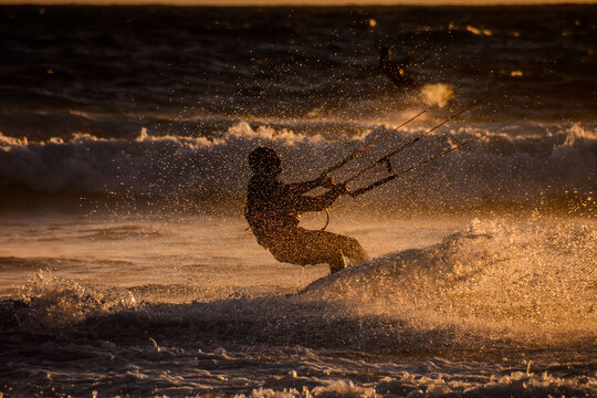 Surfer at sunset on a calm ocean, kyte surfer silhouette