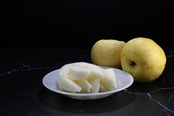 Pile of cutting fresh and organic pear serving on the plate. Famous tropical fruit in Asia restaurant. High vitamin and fiber.