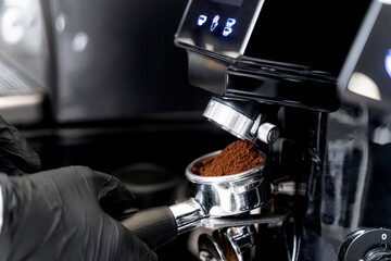 Barista makes coffee. Coffee horn by the coffee machine. The coffee is poured into the coffee horn.