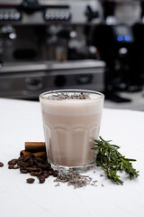 Mocha with coffee beans on white table over natural interior.