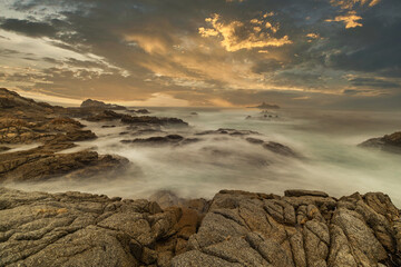 Long exposure water, beautiful seascape, ocean views, rocky coastline, sunlight on the horizon. Composition of nature. Sunset scenery background. Cloudy sky. California coast.