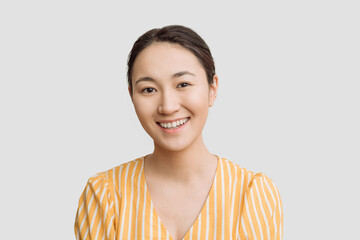 portrait of a young attractive Asian woman, a happy girl in yellow clothes smiling on a white background