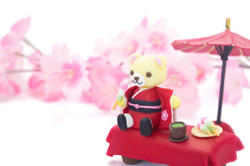 Obraz na płótnie Canvas お茶席で桜を見ながらお団子を食べるくまちゃん