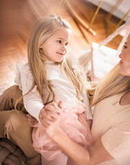 Mother and daughter playing in bedroom.