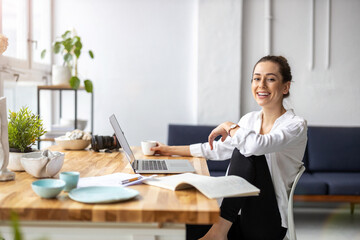 Creative young woman working on laptop in her studio
