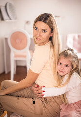 Portrait of mother and daughter in bedroom.