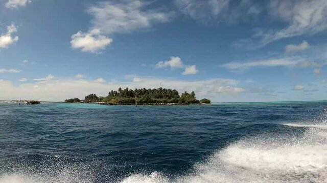 eine kleine wundersch&ouml;ne Insel und t&uuml;rkisblauem Wasser, vom Boot aus angeschaut