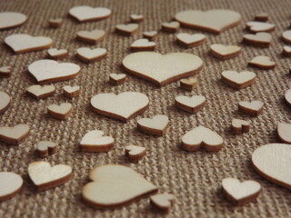 wooden hearts of different sizes on jute fabric as a Valentine's day greeting card. High quality photo