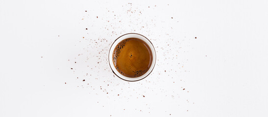 Espresso shot with circle coffee beans powder splashed around on white background top view