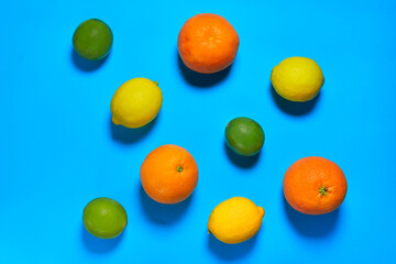 Whole oranges, limes and lemons with skin on blue background. CITRUS CITRIC