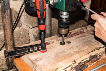 wood drilling machine working on plank and producing chips