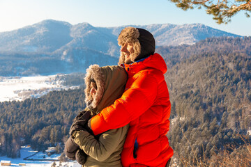 A couple in love embraces against the background of a winter landscape