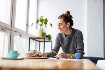 Creative young woman working on laptop in her studio
 - obrazy, fototapety, plakaty