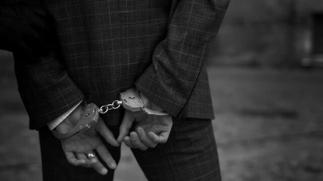 The police take the handcuffed prisoner to the prison. Detention of a suspect. Back view