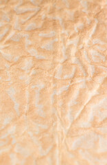 Rumpled beige background. Real texture of the wrapping texture. Gold background.
