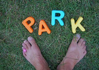 Park written in grass next to feet