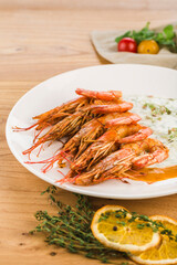 King shrimp in cream sauce in a plate on a light wooden background.