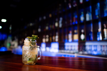 Young guy a working as a bartender while preparing cocktails in a pub
