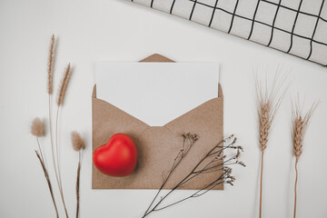Blank white paper is placed on open brown paper envelope with red heart, Many kinds of dried flowers, White cloth on Black background. Valentine's day concept #valentine #card #gift #template #mockup