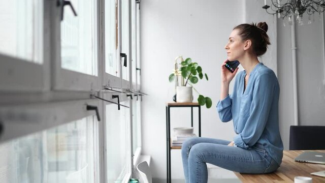 Young business woman using smartphone in loft office
