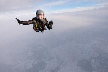 Fototapeta na wymiar Skydiving. A pretty girl is flying in the sky.