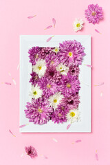 Photo frame and flowers on pastel pink background