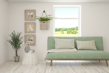 White living room with sofa and summer landscape in window. Scandinavian interior design. 3D illustration