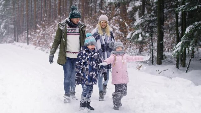 Video of family with two children walking in winter forest. Shot with RED helium camera in 8K.
