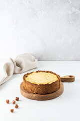 Tofu cheesecake with salted caramel and nuts on a wooden board. Vegan dessert, sugar, gluten and lactose free.