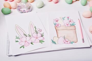 Easter eggs and flowers. Spring greeting card Happy Easter. Easter decor. Watercolor spring paintings. Designer and artist's workplace. Creative space