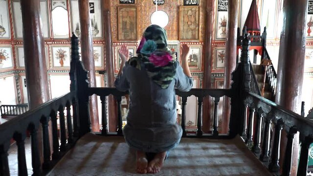 Muslim woman prays at mosque. she's asking God for forgiveness or a wish.