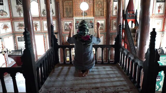 Muslim woman prays at mosque. she's asking God for forgiveness or a wish.