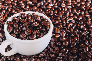 Roasted coffee beans in a white coffee cup