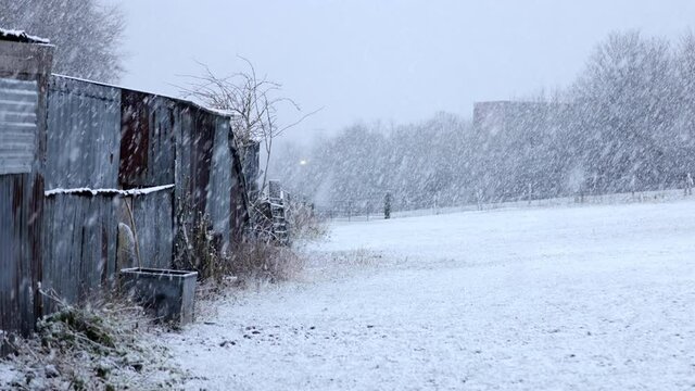 snowfall over farm fields with old outbuildings
