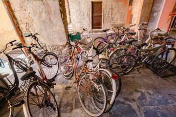 Monterosso al Mare, Italy - October, 2020: old bicycles in the dust thrown in the gateway