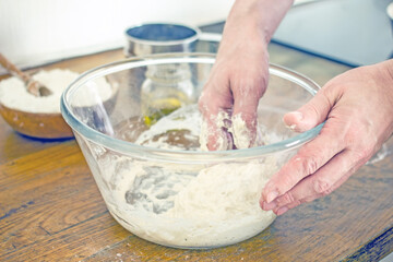 Male hands kneading dough for bread