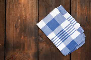 Fototapeta na wymiar folded textile blue cotton napkin on brown wooden surface