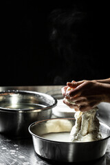 Fototapeta premium A cheesemaker prepares a form of mozzarella cheese using fresh and bio milk. The processing Traditional Italian mozzarella