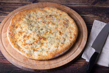 Ossetian pie with cheese and herbs (dill, parsley, scallion). Traditional Ossetian baking.