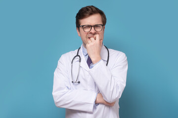 Insecure male doctor biting his nails looking funny scared craving something anxious.
